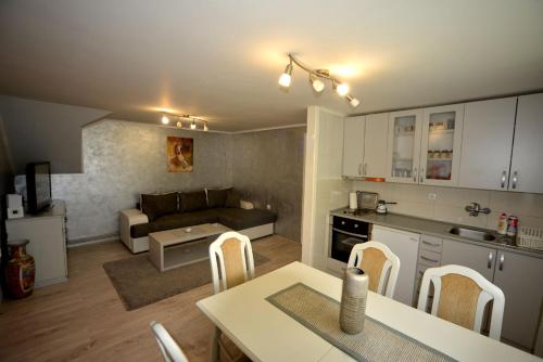 Apartment Vihor في زلاتيبور: مطبخ وغرفة معيشة مع أريكة وطاولة