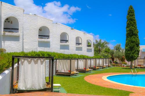 un gran edificio blanco con piscina y patio en Hôtel Mandy, en Tetuán