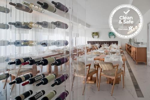 a dining room with a display of wine bottles at Furadouro Boutique Hotel Beach & SPA in Ovar