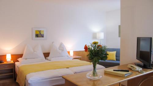 une chambre d'hôtel avec un lit et une télévision dans l'établissement Am Spiegeln dialog.hotel.wien, à Vienne