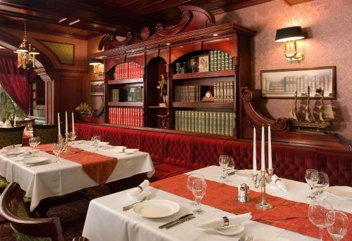 a restaurant with two tables with white tablecloths at Golden Ball Club in Győr