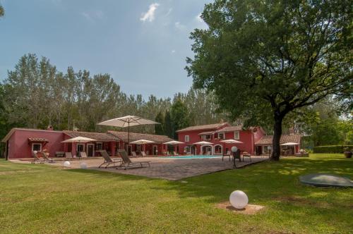 a yard with a park with a building and a tree at Agriturismo Oasi Torre Del Colle in Bevagna