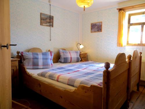 - une chambre avec un lit en bois, des oreillers et une fenêtre dans l'établissement Ferienhaus Pfeiffer, à Neusitz