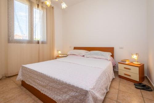 a bedroom with a white bed and a window at Villa Pietro in Lascari