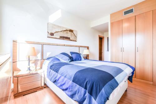 マドリードにあるBonito piso luminoso en urbanización de lujoのベッドルーム1室(青いベッド1台付)