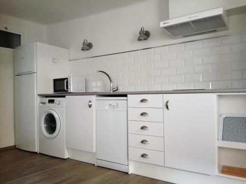 cocina blanca con lavadora y lavadora en Apartamento Torreón de la Bombardera en Teruel