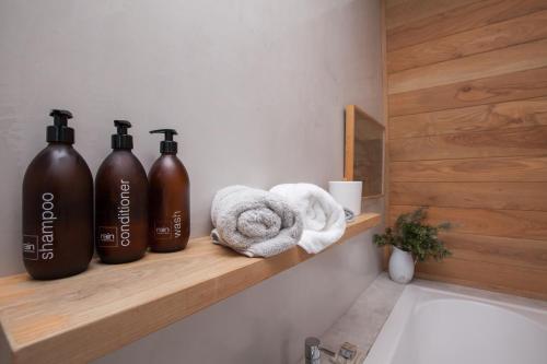 een badkamer met drie flessen op een plank naast een wastafel bij Tides' Song in Agulhas