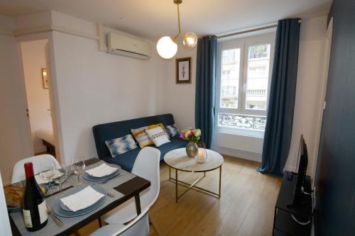 a living room with a couch and a table with a dining room at HolidaysInParis - Republique in Paris