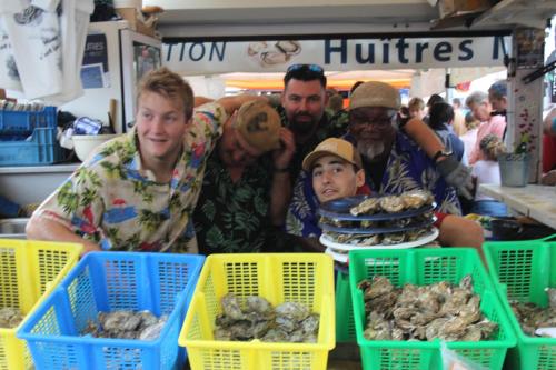 Un groupe de personnes autour d'une table avec des paniers de champignons dans l'établissement les copains d abord, à Vendays-Montalivet