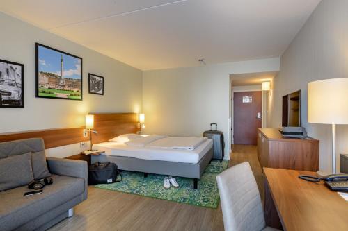 a hotel room with a bed and a couch at Mercure Stuttgart Sindelfingen an der Messe in Sindelfingen