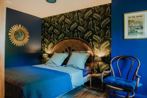 a blue bedroom with a bed and a chair at La Maison Augustine in Gap