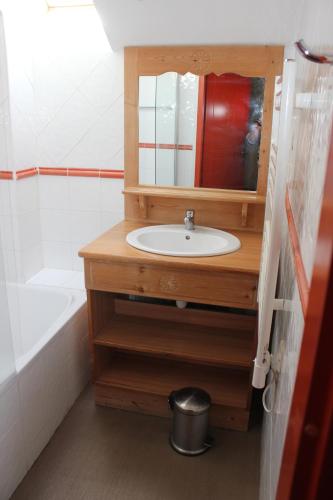 een badkamer met een wastafel, een spiegel en een bad bij Chalets de Praroustan by Actisource in Pra-Loup