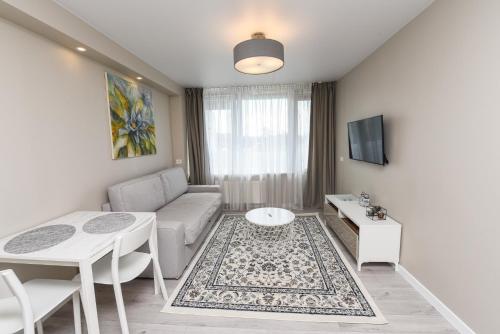 un soggiorno con un divano e un tavolo di Cozy Seaside Studio a Palanga