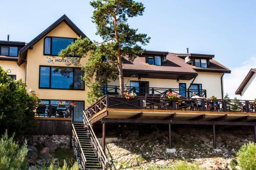 a building with a deck and a restaurant at Villa Anna in Apšuciems