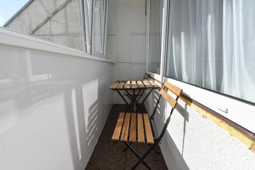 balkon z dwiema drewnianymi ławkami obok okna w obiekcie Cozy Seaside Studio w Połądze