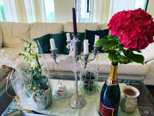 - une table avec une bouteille de vin et des fleurs dans l'établissement Villa CorteOlivo Rooms, à Torri del Benaco