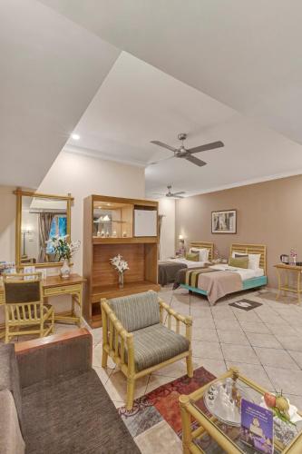 a living room with two beds and a couch at Club Mahindra Emerald Palms, Goa in Varca
