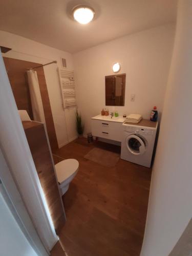 a bathroom with a toilet and a washing machine at Apartament Ustka in Ustka