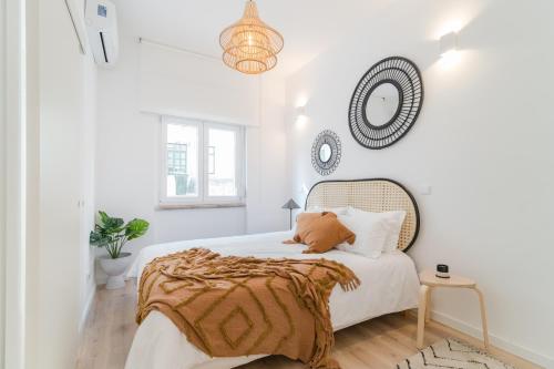 a white bedroom with a bed and a chandelier at Casa Boma Lisboa - Architect Apartment with Private Terrace - Alcantara III in Lisbon