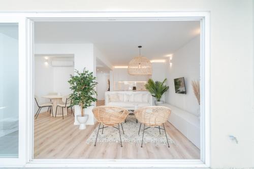 a white living room with a table and chairs at Casa Boma Lisboa - Architect Apartment with Private Terrace - Alcantara III in Lisbon