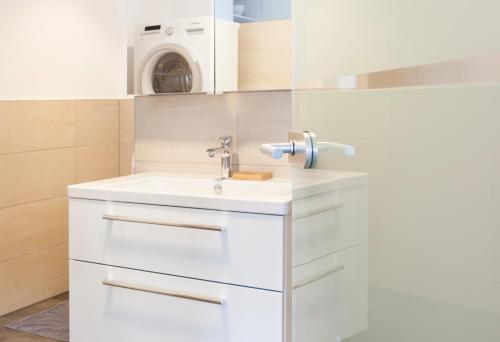 a bathroom with a sink and a washing machine at Isiliving in Montabaur