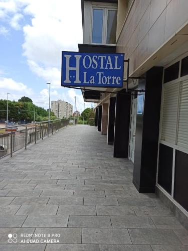 a building with a sign for a hospital la store at Hostal La Torre in Santander