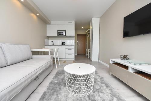 un soggiorno con un divano bianco e un tavolo di Cozy Seaside Studio a Palanga