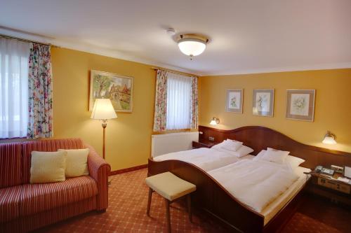 a hotel room with a bed and a couch at Hotel Brauereigasthof Landwehr-Bräu in Reichelshofen