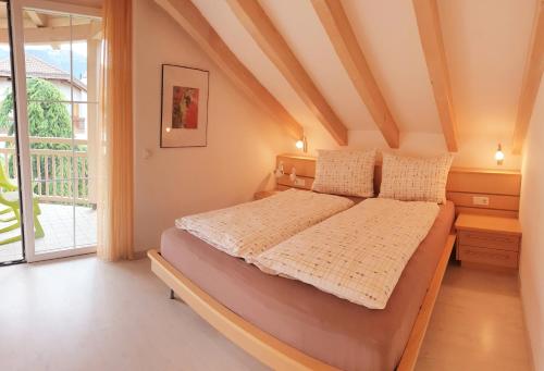 a bedroom with a bed and a large window at Villa Trogerhof in Ora/Auer