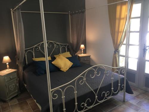 - une chambre avec un lit à baldaquin et des oreillers bleus dans l'établissement Mas de la Pinède ex-Les Arbousiers, à Bollène
