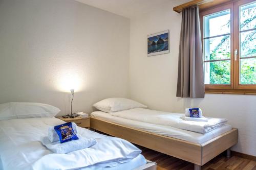 - 2 lits dans une chambre avec fenêtre dans l'établissement Apartment Dolomit EG - GRIWA RENT AG, à Grindelwald