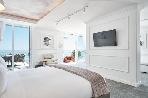 a white bedroom with a bed and a tv at The Marly Boutique Hotel in Cape Town