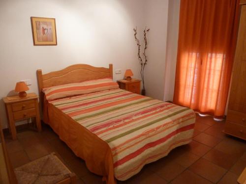 a bedroom with a bed with a striped blanket on it at Can Panxeta in Pallaresos