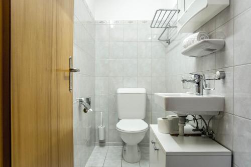 La salle de bains blanche est pourvue de toilettes et d'un lavabo. dans l'établissement Apartment Dolomit EG - GRIWA RENT AG, à Grindelwald