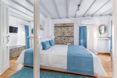 1 dormitorio con 1 cama grande con almohadas azules en Myrtia House Skopelos en Skopelos Town