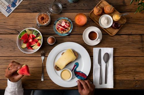 eine Person, die mit einem Teller Essen an einem Tisch sitzt in der Unterkunft Boutique Hotel De Vier Patriciërs in Middelburg