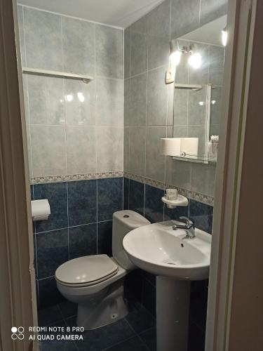 a bathroom with a toilet and a sink at Hostal La Torre in Santander