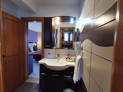 a bathroom with a sink and a person in a mirror at Sidari Waterpark in Sidari