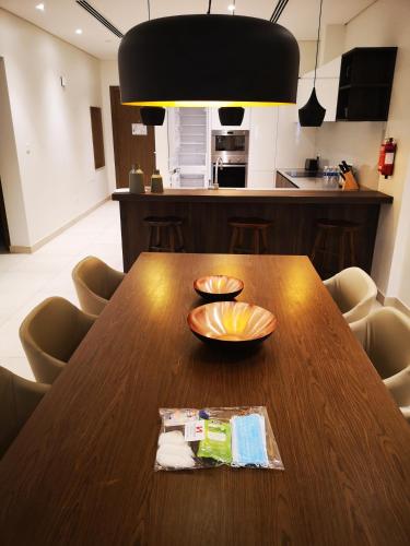 a wooden table in a kitchen with two bowls on it at Swiss-Belresidences Juffair in Manama