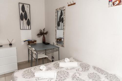 1 dormitorio con cama, escritorio y espejo en סטודיו ליה - studio lia eilat en Eilat