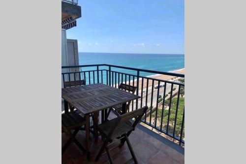 a table and chairs on a balcony with the ocean at Apartamento primera línea de Mar Enjoy the view in Blanes