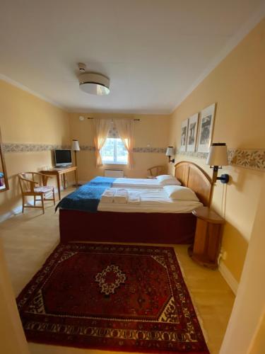 a bedroom with a large bed and a table at Broby Gästgivaregård in Sunne