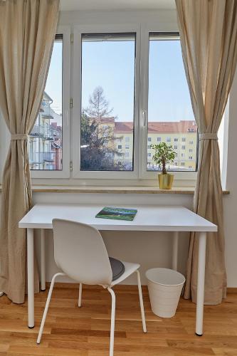 a white desk and a chair in front of a window at Gemütliche Wohnung in zentraler Lage in Graz