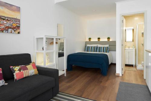 a living room with a bed and a couch at Cozy Studio Alvalade in Lisbon