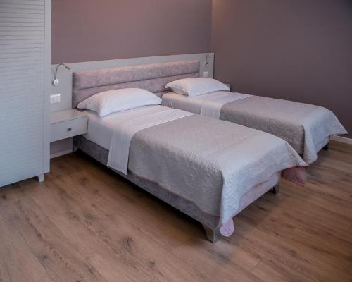two beds sitting next to each other in a room at ODA Aparthotel Shkodër in Shkodër