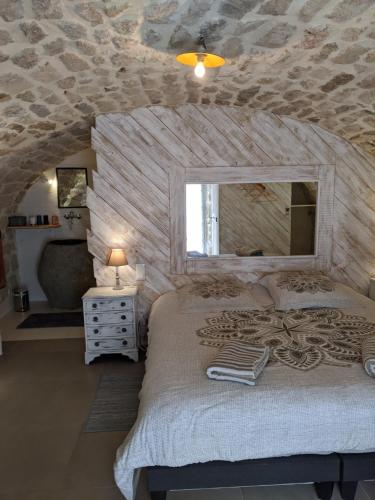 a bedroom with a large bed with a stone wall at Domaine des hauts de Vernon in Vernon