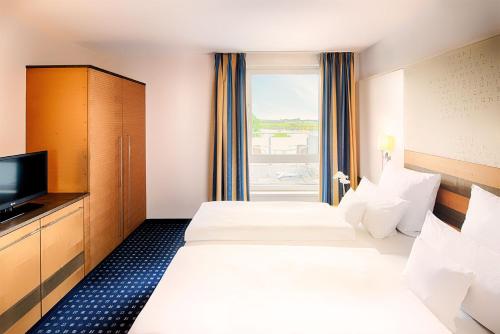 een hotelkamer met 2 bedden en een raam bij Welcome Hotel Wesel in Wesel