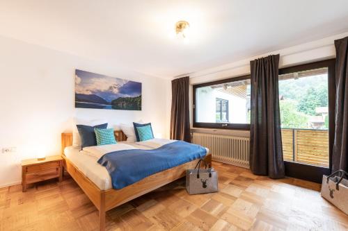 a bedroom with a bed and a large window at Chalet Annemarie Hohenschwangau in Hohenschwangau