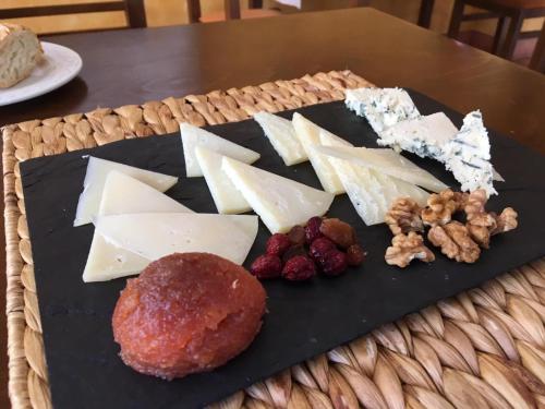 a plate of cheese and other foods on a table at Hotel Restaurante La Alhama in Medina de Pomar
