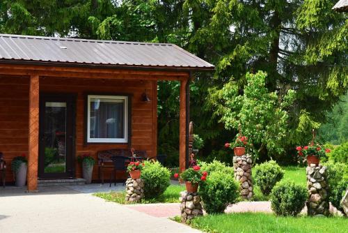 a cabin with flowers and plants in a yard at Svajonių Dvaras in Balninkai